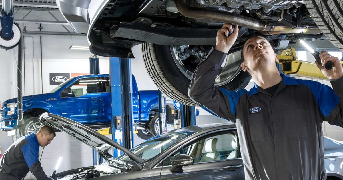 A service technician performing service on a vehicle in the service center.